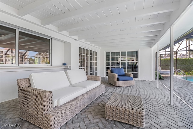 sunroom with beam ceiling and an outdoor living space