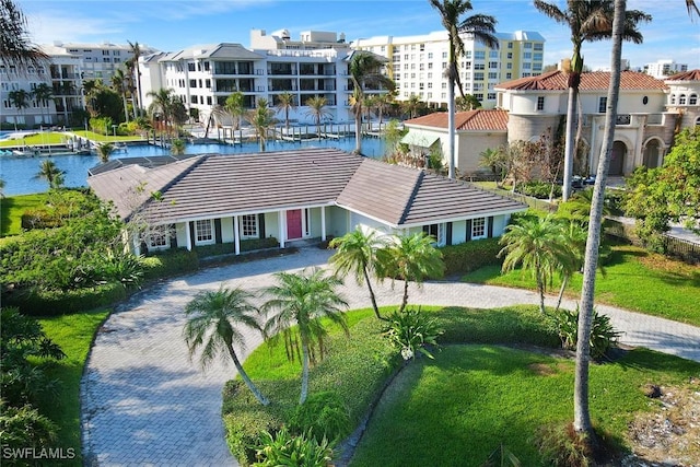view of property with a water view, driveway, and a residential view