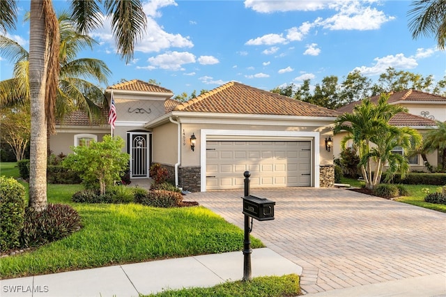 mediterranean / spanish home featuring a front yard and a garage