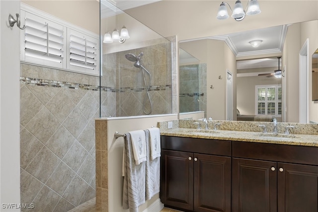 bathroom featuring ceiling fan with notable chandelier, a tile shower, vanity, and ornamental molding