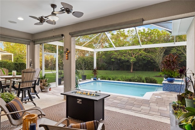 view of pool with a lanai, a fire pit, ceiling fan, and a patio area