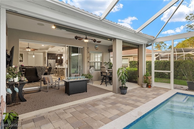 sunroom featuring ceiling fan and a pool