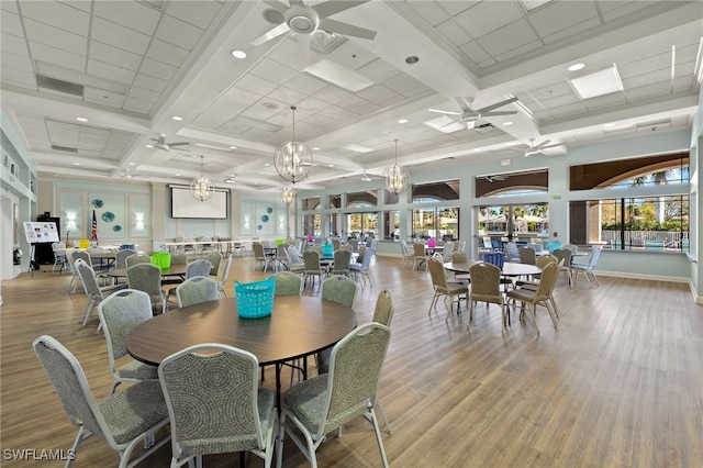 dining area featuring light wood-type flooring, plenty of natural light, coffered ceiling, and ceiling fan