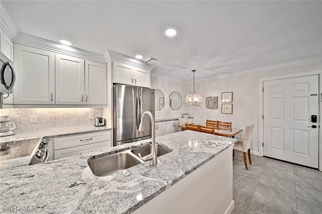 kitchen featuring pendant lighting, sink, light stone countertops, white cabinetry, and stainless steel appliances