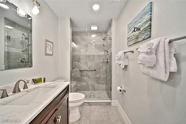 bathroom with tile patterned floors, vanity, a shower with shower door, and toilet