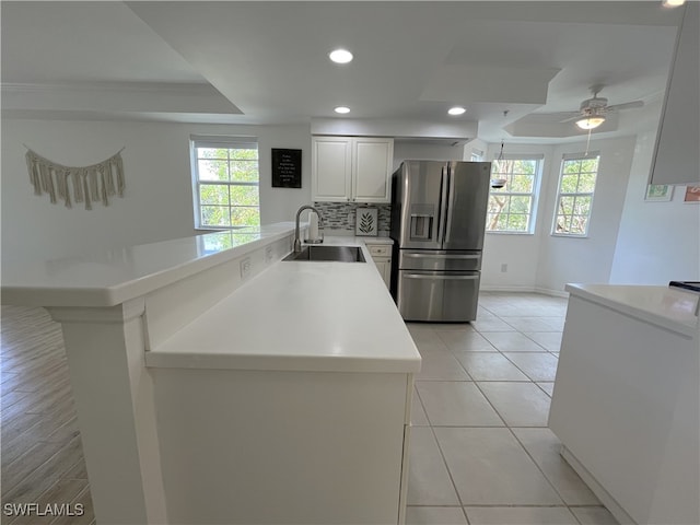 kitchen featuring white cabinetry, sink, ceiling fan, stainless steel fridge with ice dispenser, and kitchen peninsula