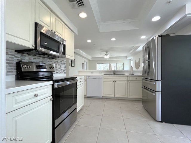 kitchen featuring sink, stainless steel appliances, crown molding, decorative backsplash, and white cabinets