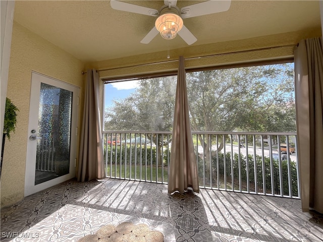 unfurnished sunroom featuring ceiling fan