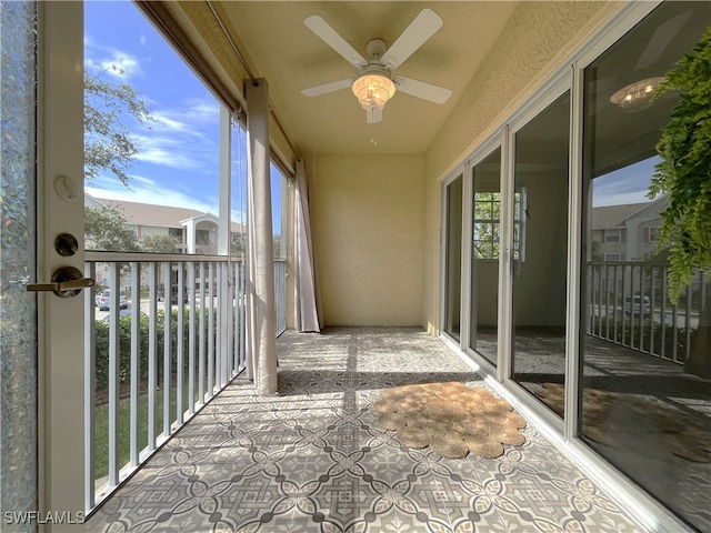 unfurnished sunroom featuring ceiling fan