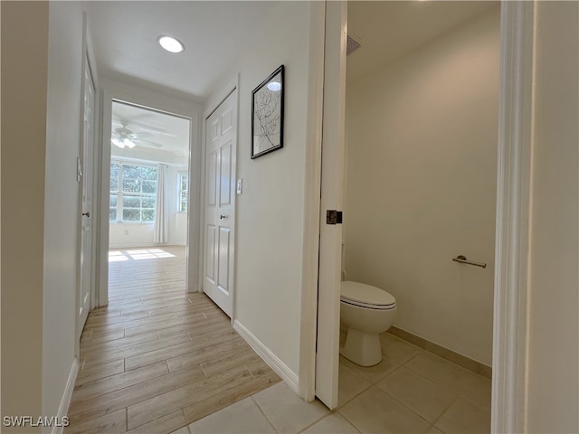 bathroom with ceiling fan, toilet, and wood-type flooring