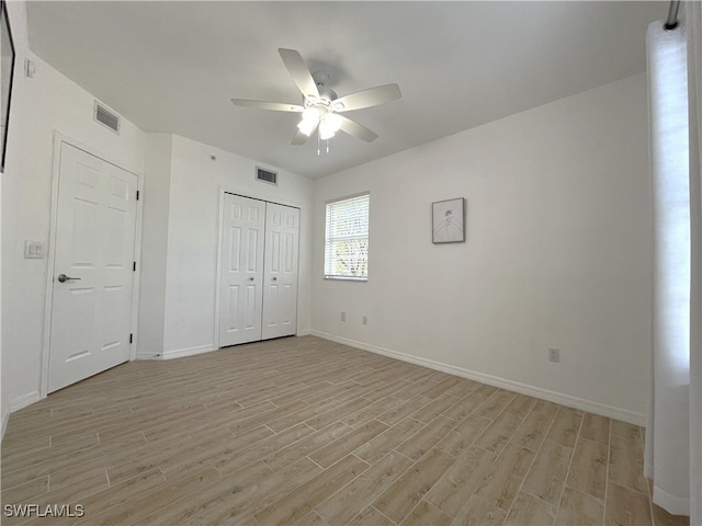 unfurnished bedroom featuring light wood-type flooring, a closet, and ceiling fan