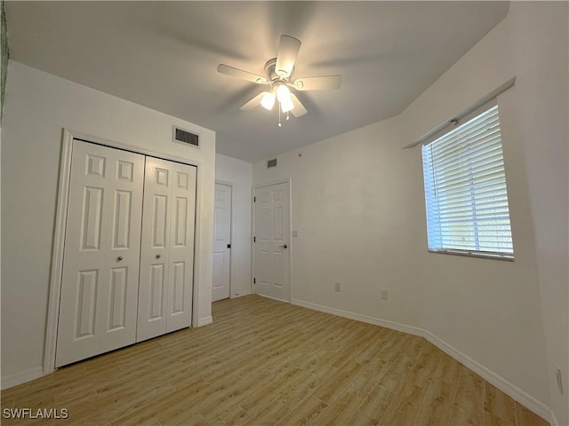 unfurnished bedroom with ceiling fan, light wood-type flooring, visible vents, and baseboards