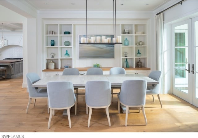 dining room featuring french doors, light hardwood / wood-style floors, and crown molding