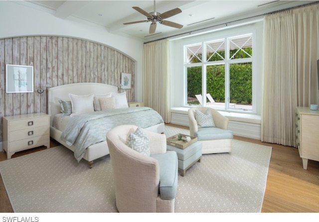 bedroom featuring beamed ceiling, light hardwood / wood-style floors, and ceiling fan