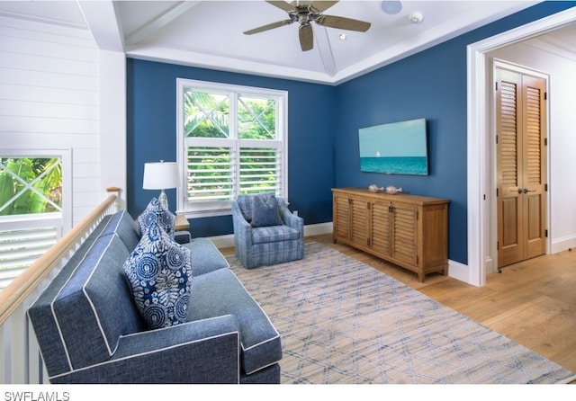 living room featuring ceiling fan, lofted ceiling, and light wood-type flooring