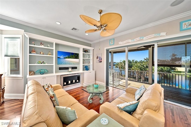 living room with hardwood / wood-style flooring, ceiling fan, and ornamental molding