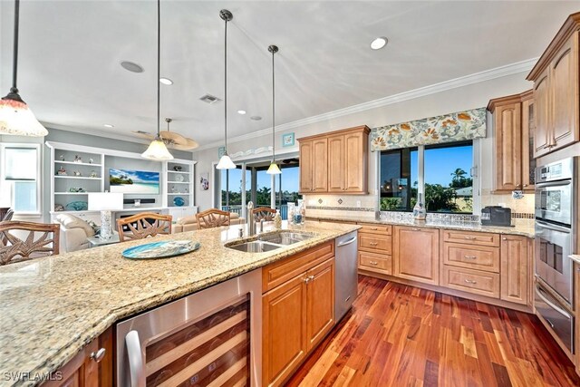 kitchen with plenty of natural light, hanging light fixtures, and beverage cooler