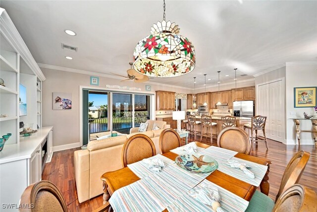 dining area with dark hardwood / wood-style floors, ceiling fan, and crown molding