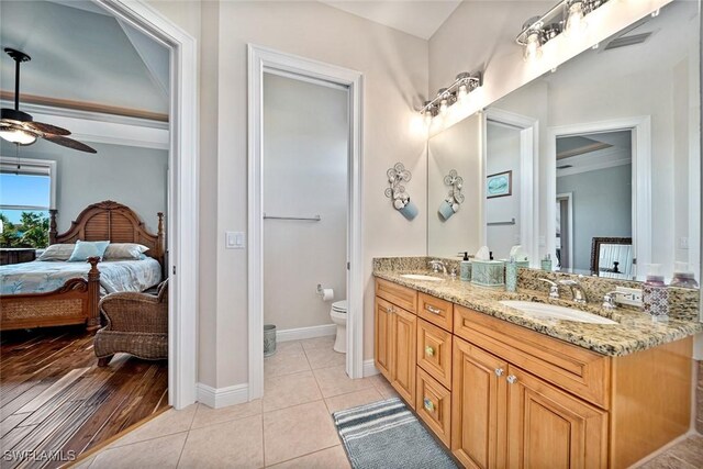 bathroom featuring hardwood / wood-style floors, vanity, crown molding, ceiling fan, and toilet