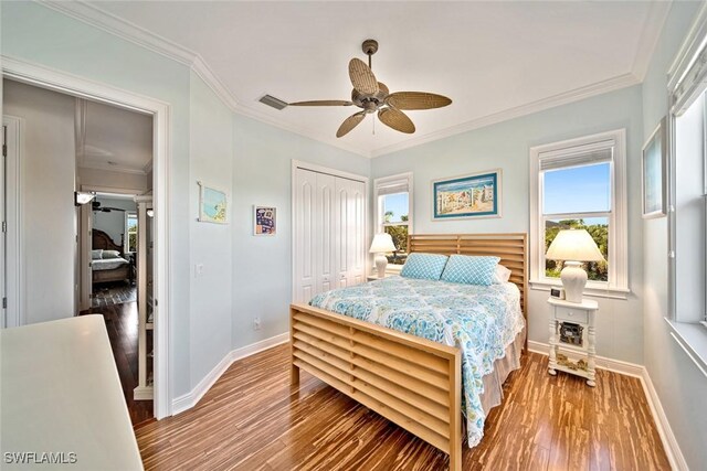 bedroom featuring ceiling fan, a closet, crown molding, and hardwood / wood-style flooring