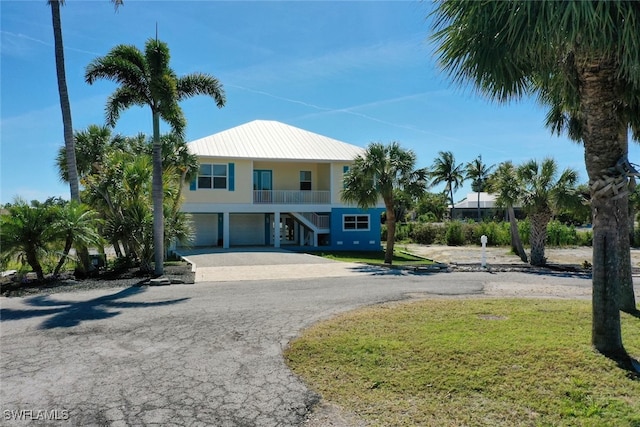 raised beach house with a garage and a front yard