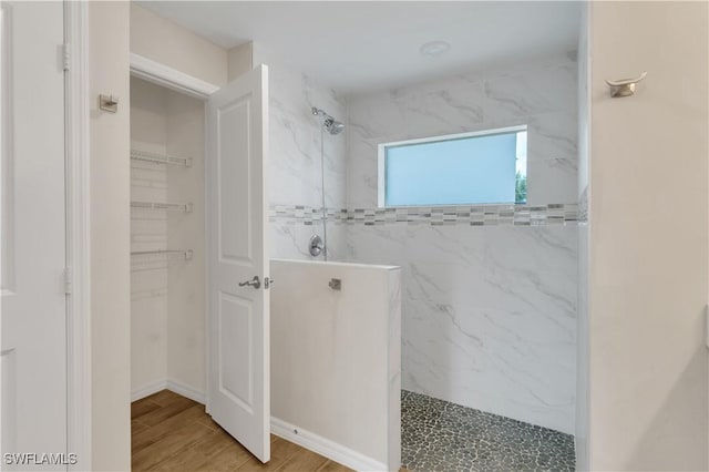 bathroom with hardwood / wood-style flooring and tiled shower