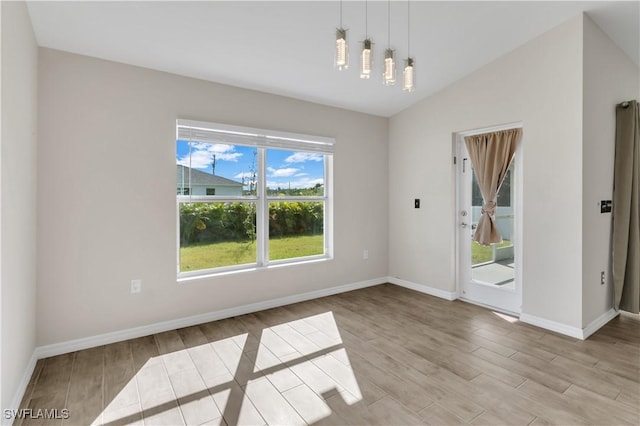 unfurnished dining area featuring lofted ceiling and light hardwood / wood-style flooring