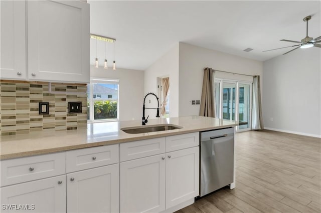 kitchen featuring white cabinets, light stone counters, sink, dishwasher, and light hardwood / wood-style floors