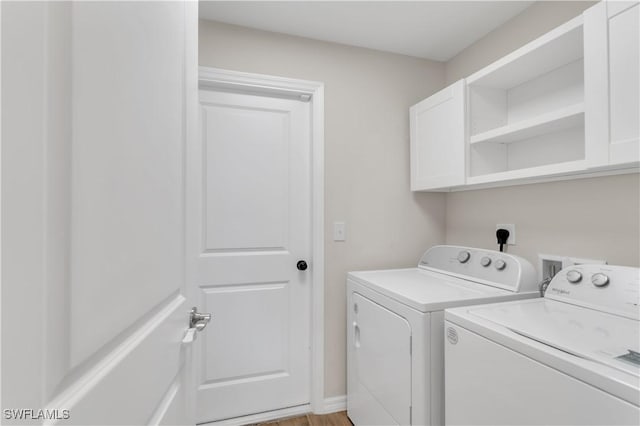 washroom with cabinets, independent washer and dryer, and light hardwood / wood-style flooring