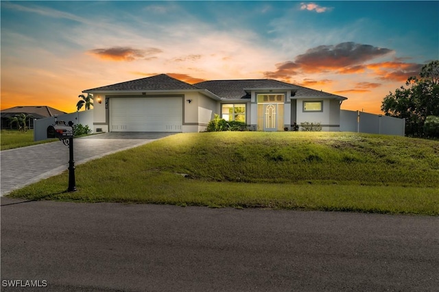 view of front of home featuring a garage and a lawn