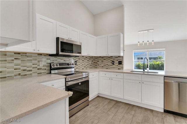 kitchen with white cabinetry, light hardwood / wood-style flooring, stainless steel appliances, and sink