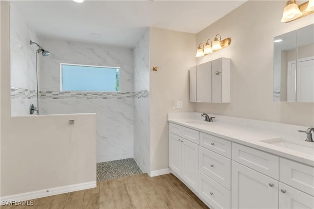 bathroom with a tile shower, vanity, and hardwood / wood-style flooring