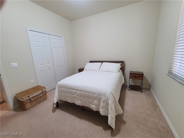 bedroom featuring a closet and light colored carpet