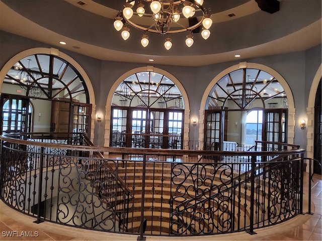 hallway featuring tile patterned flooring, french doors, and an inviting chandelier