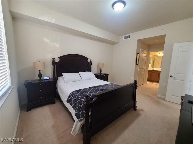 carpeted bedroom featuring ensuite bath