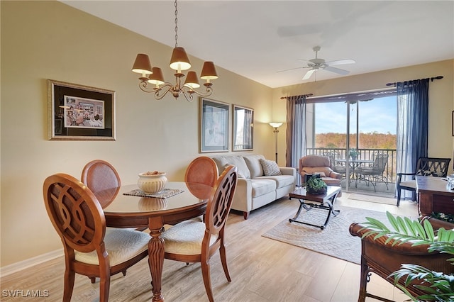 dining space with ceiling fan with notable chandelier and light wood-type flooring