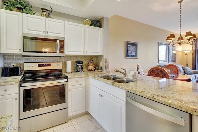 kitchen with pendant lighting, sink, white cabinetry, stainless steel appliances, and decorative backsplash