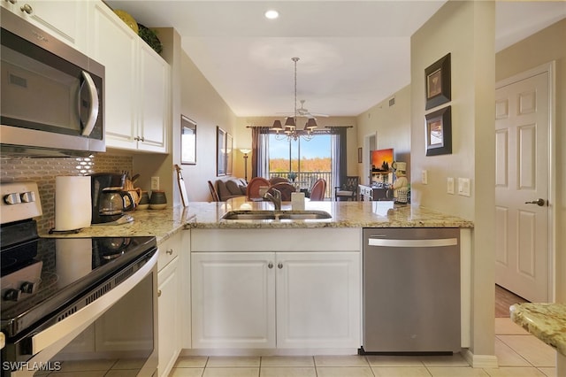 kitchen with white cabinets, sink, appliances with stainless steel finishes, a notable chandelier, and kitchen peninsula