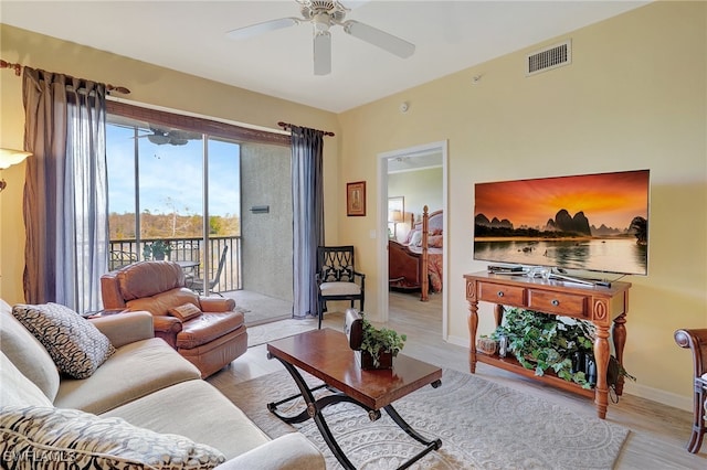 living room with light hardwood / wood-style floors and ceiling fan