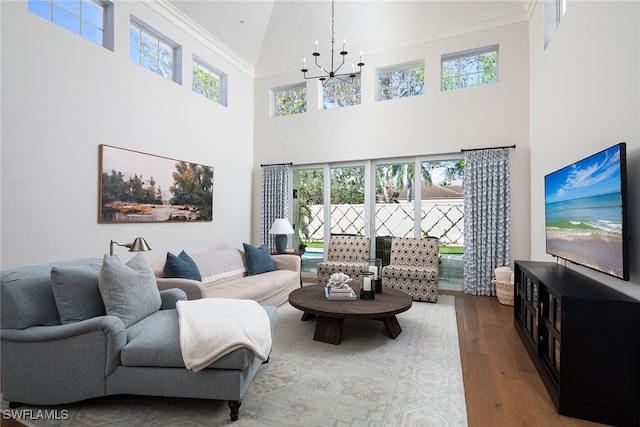 living room with crown molding, a healthy amount of sunlight, a high ceiling, and wood-type flooring