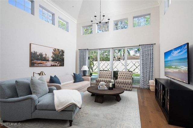 living room featuring wood-type flooring, ornamental molding, and plenty of natural light