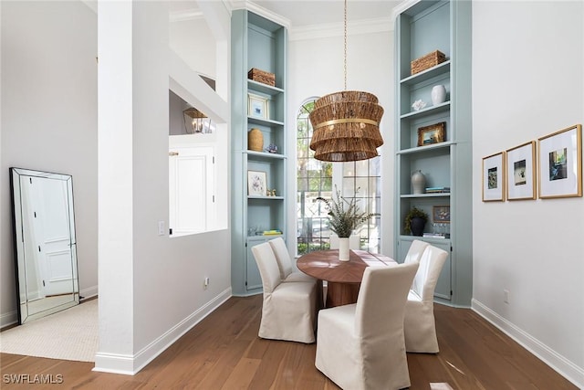 dining space with hardwood / wood-style flooring, crown molding, and built in features