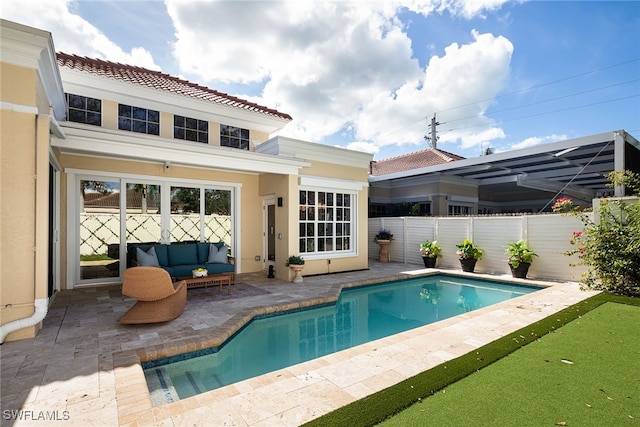 back of house featuring a fenced in pool, an outdoor living space, and a patio area