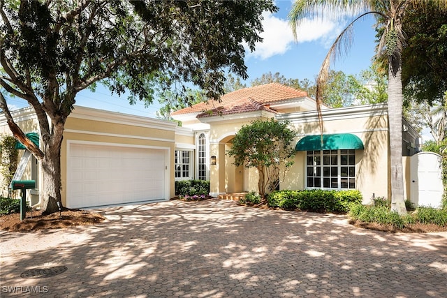 mediterranean / spanish-style house with a garage