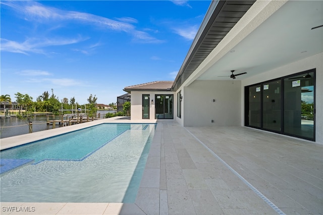 view of pool featuring ceiling fan, a water view, and a patio area