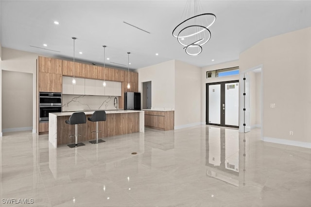 kitchen with white cabinetry, black fridge, decorative light fixtures, stainless steel double oven, and a notable chandelier