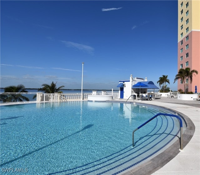 view of swimming pool with a patio and a water view