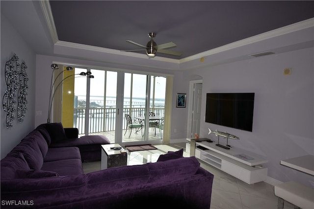 living room featuring a raised ceiling, ceiling fan, and crown molding