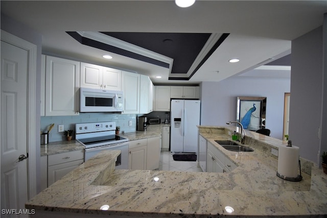 kitchen featuring crown molding, white appliances, sink, and a tray ceiling