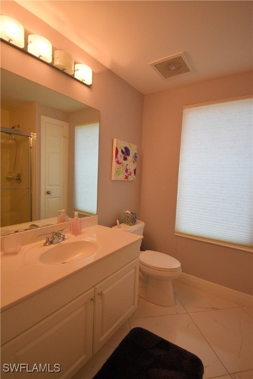 bathroom featuring vanity, toilet, and a shower with shower door